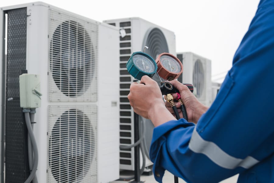 Technician is checking air conditioner at commercial business.
