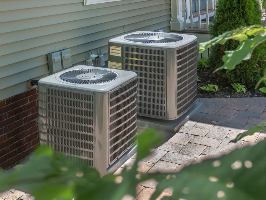 two air conditioning units on the side of the house