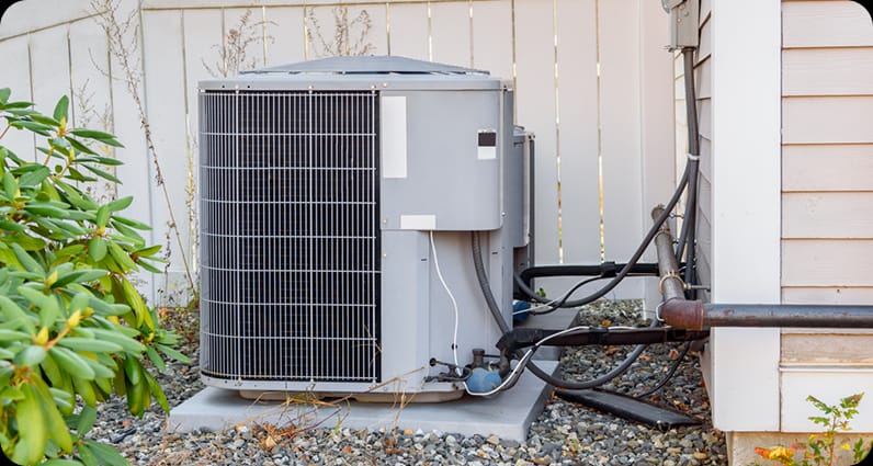 air conditioning unit outside against fence