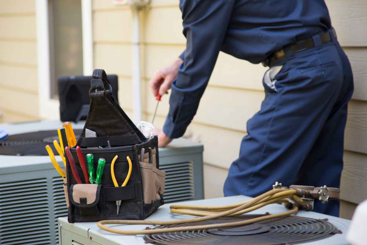 Senior Adult air conditioner Technician/Electrician services outdoor unit.